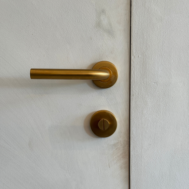 Zeer luxe toiletsluiting in het mat goud. Hier toegepast op een met kalkverf bewerkte deur