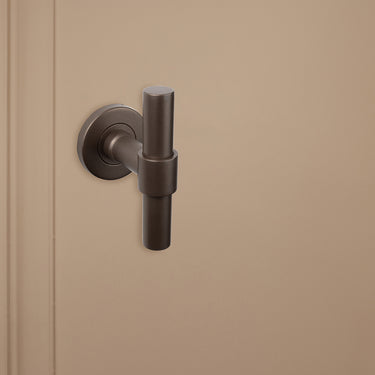 Exclusieve bronzen T-klink Pesaro van Lavuzo op beige achtergrond, linkeraanzicht
