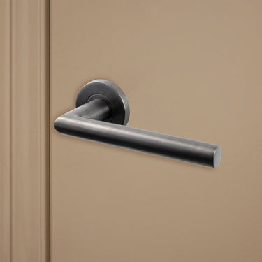 Gun Metal PVD gecoate Ragusa deurklink op rond rozet op beige binnendeur, rechteraanzicht